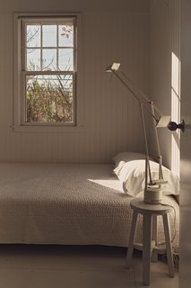 Damaged by Superstorm Sandy, a Fire Island Cottage is Rebuilt - Photo 3 of 6 - The all-white guest bedroom features a West Elm bed, covers by Garnet Hill, and a Tizio desk lamp by Richard Sapper for Artemide