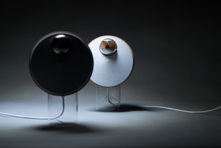 A Playlist for Prototypes - Photo 3 of 5 - BeoLab S, designed by Tuomas Hämäläinen, aimed to combine the simplicity of one-point music systems with the wide sound stage of traditional stereo speaker systems. The warm, wooden loudspeakers perch atop translucent cylindrical stands. 
