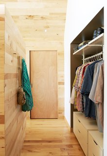 Happy Trails - Photo 6 of 7 - IKEA’s Stolmen system holds the couple’s clothes in the master bedroom. Solid core maple doors from Lowe’s match the structure’s interiors, which are lined in wood largely sourced from Union Church Millworks. 