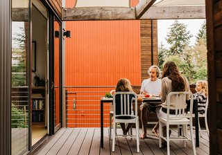 The Davis family—Everett, Jonathan, Mary Jo, and Dashwood—enjoy a meal around a Room & Board Montego dining table at their home in The Village. Their residence is the "Aria" style, one of four house types available in The Village. At 1,549 square feet, Aria houses feature two bedrooms.
