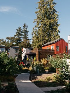 Clad in a mix of stained cedar, Metal Sales corrugated siding, and James Hardie cement board, houses in The Village are arranged along winding paths intended to provide opportunities for neighbors to interact.