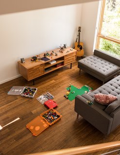 Chris and Wendy Kozina live with their son, Ben, in a "Tallis" style town house. They selected bamboo floors for the 1,155-square-foot, two-bedroom interior. The family strives to cap their possessions at 500 items—Legos not included. In the living room, an Innes media cabinet from Room & Board is paired with a Gus Modern sectional.