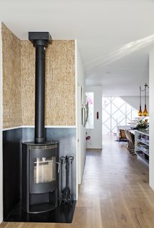 Such Great Heights - Photo 5 of 13 - Upcycled Kirei wall board pairs with a Rais Gabo stove in the original part of the house, which connects seamlessly <br>to the prefab addition.