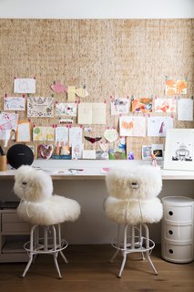 Such Great Heights - Photo 8 of 13 - Industrial stools covered in sheepskin sit at the art nook off the dining area. Sydney’s artworks line the Kirei wall panels.
