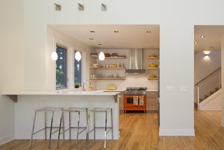 For the open kitchen, Peter, a former chef, ordered a colorful Bertazzoni range through a showroom in Portland, then decorated the rest of the space around it. The fixture contrasts with the neutral walls, which are painted in Rodda’s Dove White.