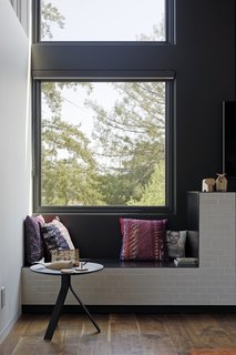 The pillows, wooden animal figures, and tray-top side table near the large window.