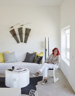 Hill sits <br>on a Casalino chair from Design Within Reach in the living room; on the wall is Quivers, a sculpture by her daughter, Claire Cusak. Collaborator George Sacaris made the stump table. 