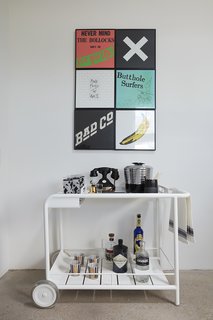 A Fermob cart holds vintage barware beneath a collection of favorite album covers. 