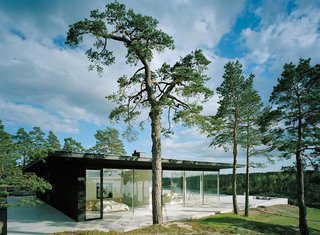 10 Modern Homes That Made a Star Appearance in Films - Photo 2 of 16 - The matte black exterior and floor-to-ceiling glass of Villa Överby sit flush on limestone slabs.