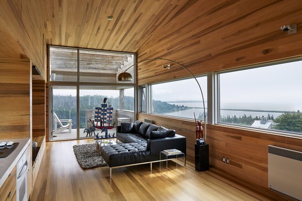 “At Sliding House, the outside world is more present,” says Rhonda, “always visible through the sliver of window that runs across the length of the house and down to the ground.” The living area’s Carter leather sectional is by Gus Modern, and the boat carving is by local folk artist Bradford Naugler. The family sought to source Canadian furnishings and materials as much as possible. Photo 7 of Sliding House modern home