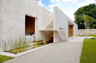 The sleek architectural lines of this contemporary getaway are dramatically set off by the great lawn and jungle that surrounds it.