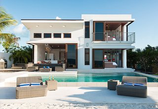 Guests can dine poolside overlooking the ocean at the Coconut Road Villa. 