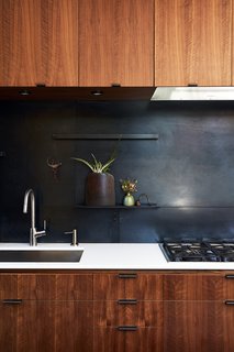 Greener Grass - Photo 4 of 14 - The metal backsplash and drawer pulls were fabricated by 12th Avenue Iron; the cooktop is by Miele. 