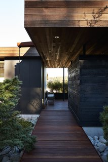 Greener Grass - Photo 8 of 14 - Generous breezeways, walkways, and overhangs frame views beyond: "It’s like a promenade, with a forest at the end of the road," says Deb.