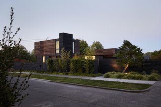 Greener Grass - Photo 10 of 14 - The home’s exterior is clad in a rich material palette of locally sourced salvaged barn wood, three types of Richlite cement board, milled cedar, and steel. Ian and Deb specified most of the plantings throughout, adding a variety of grasses, evergreen vines, and mature trees from Emery’s Garden, including a Japanese black pine that sits alongside the entrance on the west facade. 