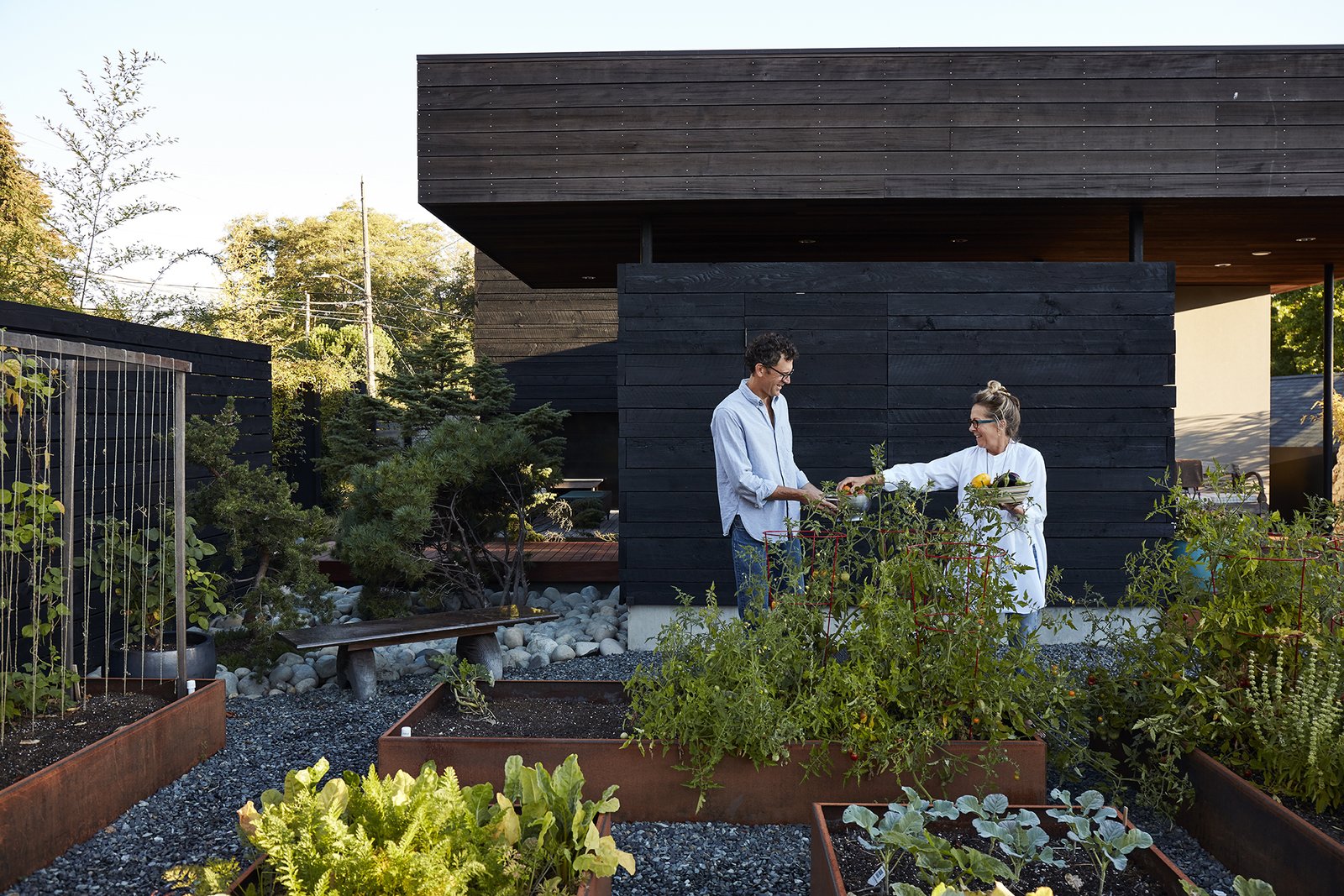 Cor-Ten steel planters host a bounty of fresh herbs, fruits, and vegetables.