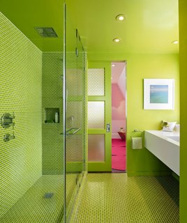Green works its magic for Min Day in this bathroom, which contrasts with the bright pink bedroom beyond.