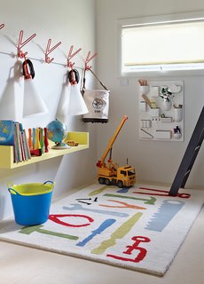 The boys’ playroom is outfitted with a Uten.Silo wall organizer by Dorothee Becker for Vitra and a pair of May Day lamps by Konstantin Grcic for FLOS that dangle from a set of Peace hooks by Louise Hederström for Maze. 