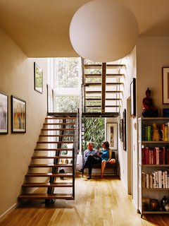 Louis did much of the woodworking in the house, including the fabrication of the <br>white oak stair treads. The ironwork was crafted by Alex and Gio Welding. A Glo Ball pendant by Jasper Morrison for Flos hangs in front of the staircase. 