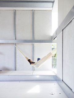 Across the Ocean - Photo 1 of 10 - Resident Débora Mesa Molina, an architect and research scientist, lounges in a hammock in the living area of the steel-and-foam prefab addition she and her husband, Anton Garcia-Abril, designed in Madrid, Spain, and assembled in nine days in Brookline, Massachusetts. 