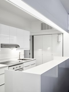 Across the Ocean - Photo 9 of 10 - Below the mezzanine, sliding panels reveal a volume containing the kitchen workspace. 