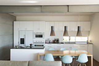 Pendants from Finnish Design Shop light a table by carpenter Leo LaPlante. The Eames chairs are from Design Within Reach. 