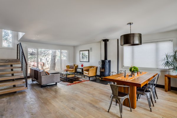 After gutting the interior to create an open floor plan, the Habilis crew installed reclaimed wood flooring that the homeowners had sourced. They painted the walls Strong White by Farrow & Ball and installed a custom metal stairs railing from local welder Joan of Arc. The stove is a Hwam Classic 7. Photo 4 of Frischkorn Ranch modern home