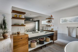 Even before Juilland started on the project, the homeowners tapped Ben Dagitz of DagitzFurniture to make a few items for the home. This included the "island" divider which Dagitz conceived. The chair rail around the perimeter of the room is painted in Farrow & Ball’s Purbeck Stone. 