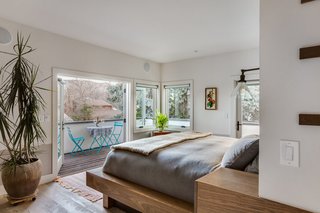 The master suite is a large space anchored by a custom-built "island" that holds the bed on one end and bathroom vanity on the other (see next slide).<br><br>"Since we didn’t want to push the whole house out to open up more space, I added a deck instead of altering the footprint," says Juilland. The result, he says, is a cozy bedroom that doesn't feel confined.