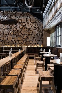 10 Cozy Spaces and 15 Products to Help You Get Ready For Fall - Photo 10 of 10 - Cross sections of tree trunks line the walls of this German-style beer house in Melbourne, Australia. With various types of wood used throughout the space, the effect is multidimensional and complex, yet still warm and approachable. It's the perfect place to welcome in fall.