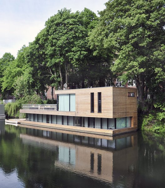 10 Modern Floating Homes That Offer an Aquatic Lifestyle - Photo 1 of 10 - In Hamberg, Germany, Houseboat on the Eilbekkanal is enveloped in sliding timber slats, creating a constant connection between the interior and the exterior. 