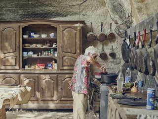 Mine Dining - Photo 2 of 18 - In the limestone kitchen embedded in the hillside, Lolo keeps only proven essentials—skillets that have been seasoned countless times and furniture that has been passed down for generations. 