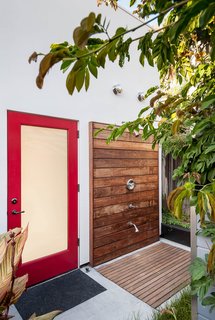 These 13 Outdoor Showers Will Make You Consider One For Your Own Yard - Photo 5 of 13 - Designed for easy beachside living, "the cube" in the backyard—essentially the renovated garage—sports a sleek outdoor shower complete with a teak deck and Moen fixtures.