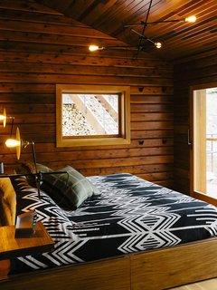 The master bedroom’s <br>custom bed has built-in storage. The lighting is by Workstead.