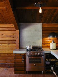 A Column lamp by Apparatus and concrete countertops join a Bertazzoni propane range. The brass pendant<br>is by Workstead.