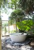 Modern home with Bath Room and Freestanding Tub. Outdoor Tub: A tucked-away bathtub provides a private backyard oasis. “We kind of got carried away,” resident Maury Strong recalls of the decision to place the 59-inch freestanding Keren basin outdoors. “My view was, ‘Let’s just do it all.”’ The extra effort paid off—the outdoor bath is among her grandchildren’s favorite parts of the house. Her husband, Ron Caron, also enjoys relaxing there. Photo 9 of Emerald Street Residence