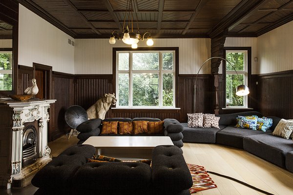 The living room on the ground level features facing Brick sofas by KiBiSi, a design firm Jens cofounded along with Bjarke Ingels and Lars Holme Larsen in 2009; the cushions, covered in Kvadrat fabric, are tied together and studded with a molded fiber-concrete button. An Arco lamp by Achille and Pier Giacomo Castiglioni for Flos extends over an On the Rocks sofa by Francesco Binfaré for Edra. Photo 2 of Skibsted Residence modern home