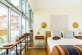 A pair of floating nightstands in the master bedroom are by Børge Mogensen; the sconces are by Kurt Versen and came with the house. The panel of fabric over the oak Matera bed from Design Within Reach is Incantation, by Lustig—the piece was originally used as a curtain. 
