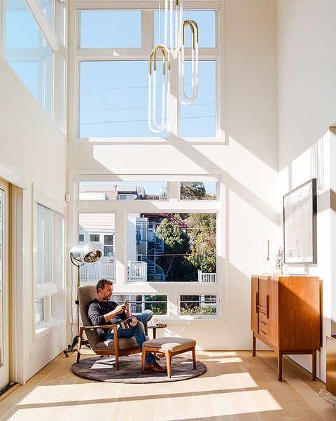 Tom and Kate own the top two floors of the building. On the lower level, in the double-height foyer, Milo Baughman’s Recliner 74 is positioned beneath Rudi Double Loop pendants by Lukas Peet for Roll & Hill. The floor lamp is a custom piece that De Angelis Designs adapted from a vintage salon hood dryer. Photo 3 of Conrad Residence modern home