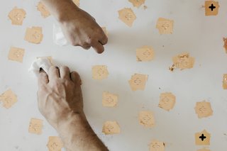 Paper Trail - Photo 12 of 16 - Apply Copperleaf: The team then uses cheesecloth to apply copperleaf squares to the areas where the sizing was administered. 