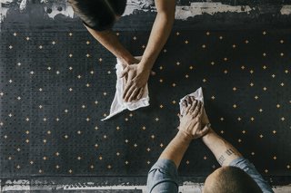 Paper Trail - Photo 16 of 16 - Buff: The paper is hand-buffed to create a polished finish, a step that requires two hardworking sets of hands.