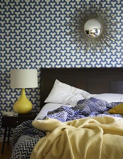 How to Update a Midcentury Modern Gem - Photo 12 of 12 - A sunburst mirror, which George bought on eBay, pops against patterned Antonina Vella wallpaper in the guest bedroom. The lamp is vintage. 