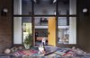 Modern home with Outdoor. By scouring shops, sales, and auctions, George Marrone amassed a giant trove of postwar furniture. He and his partner, Michael Nocera, applied that same work ethic to a 1959 home in Wilmington, Delaware, which they patched up over two years. The couple’s bulldogs stand guard at the flagstone entrance. The door, still with its Space Age knobs, is painted Flaming Torch by Behr. The brass wallhanging above the landing is by C. Jeré. Photo 2 of The Marrone/Nocera Residence