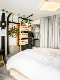 Devising Clever Solutions For a Small San Francisco Loft - Photo 5 of 10 - The custom overhead light is a pine box covered in linen, which diffuses the LEDs inside. A gray linen curtain conceals his tools.