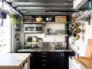 Devising Clever Solutions For a Small San Francisco Loft - Photo 6 of 10 - The kitchen, located behind the stairs and underneath Max’s bedroom, is all electric, with two burners, a rice cooker, a slow cooker, and a toaster oven. Max added industrial shelving and a butcher block. "Vertical storage," he notes, "is very important."