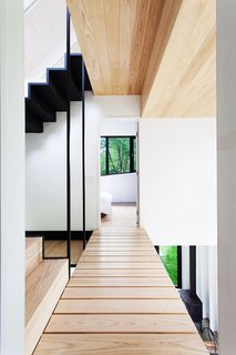 Architects Marie-Claude Hamelin and Loukas Yiacouvakis connected the home’s three levels in dramatic fashion. Ash treads float on a steel stringer from the ground floor to the mezzanine.