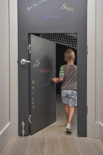 Child’s Play: Designing a Polished, All-Ages Playscape - Photo 5 of 8 - In certain places, the scale of the home is adjusted for children. A standard door, covered in chalk-board paint, has a 48-inch-tall door set inside it. 