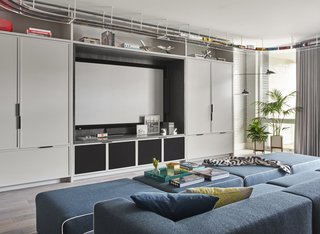 Child’s Play: Designing a Polished, All-Ages Playscape - Photo 7 of 8 - In addition to the triplex’s first-floor movie room, there is a rooftop theater with a miniature golf course. A custom sofa and ottomans are upholstered in felted wool by Maharam.