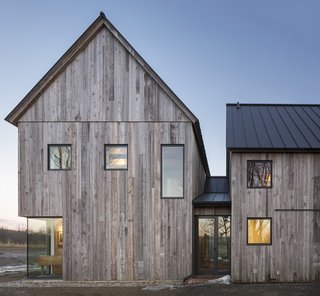 An Artist and Farmer Work With a Toronto-Based Studio to Build a Barn-Inspired Home - Photo 1 of 11 - A combination of Alumilex and Marvin windows dot the exterior of a pitched-roof house in North Hatley, Quebec, designed by Lee and Macgillivray Architecture Studio (LAMAS). 