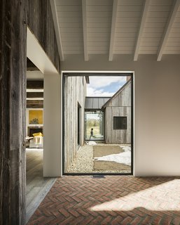 An Artist and Farmer Work With a Toronto-Based Studio to Build a Barn-Inspired Home - Photo 2 of 11 - The placement of the windows creates sight lines across the 4,770-square-foot structure. Northern Wide Plank sourced the reclaimed hemlock for the facade; Sherma Construction picked the specific boards to create a cohesive look. 